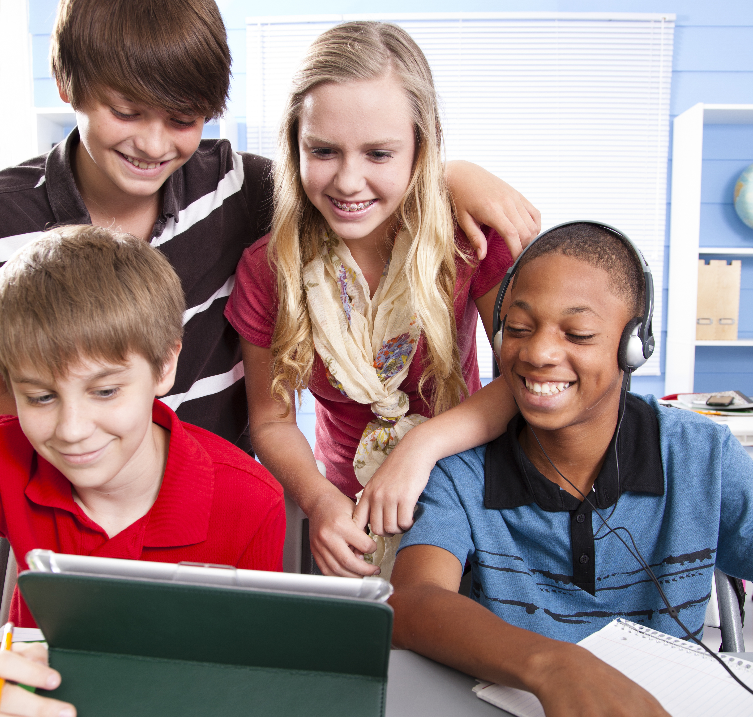 Multi ethnic Preteen students in computer lab enjoying digital tablet